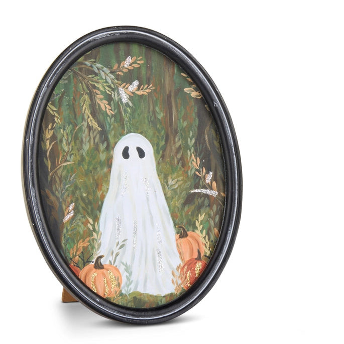 An oval framed art print featuring a white ghost standing among pumpkins in an autumn forest, set against a plain white background.