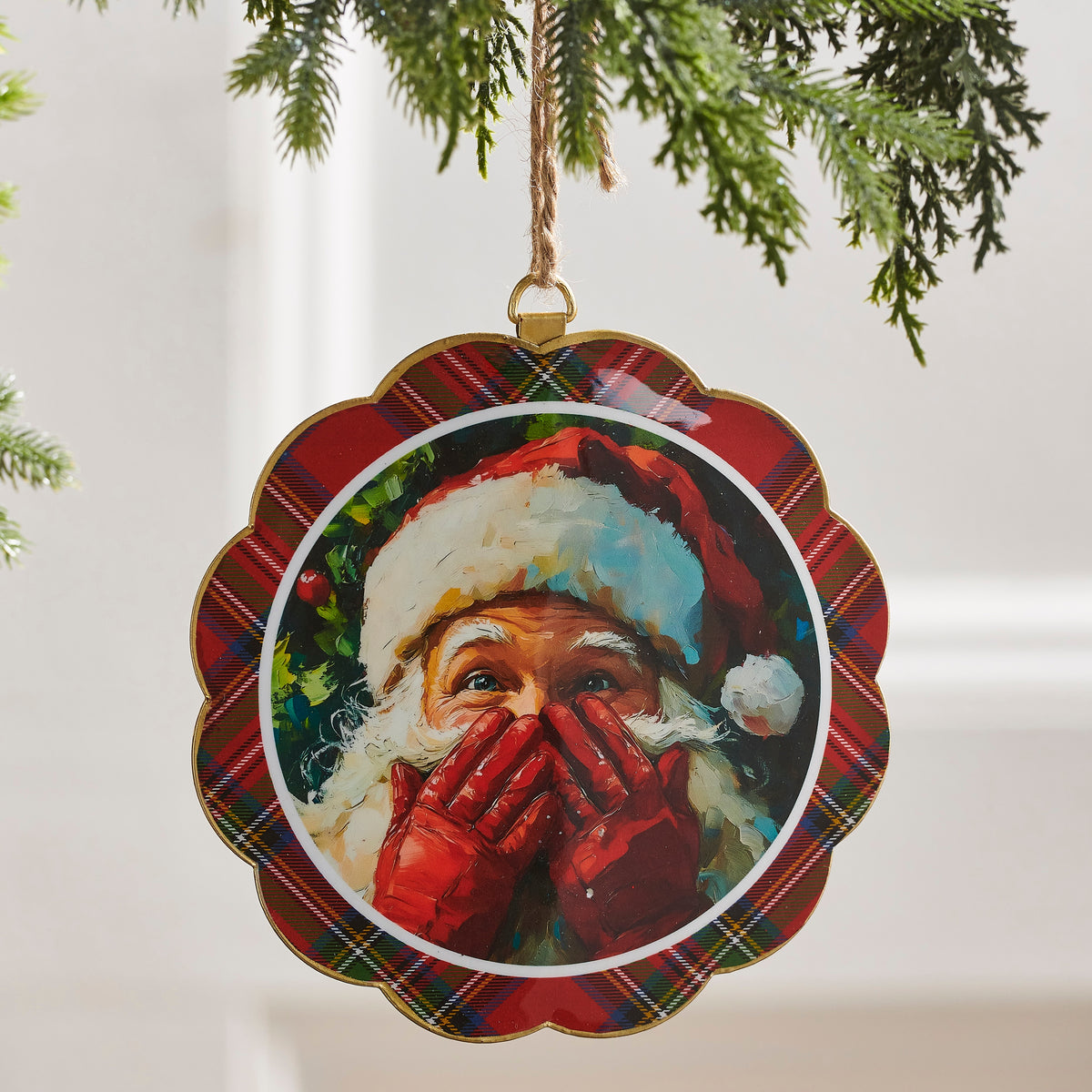Santa's Secret Scalloped Disc Ornament hanging from a tree