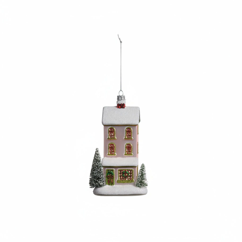 pale pink town house ornament with a green door on a white background
