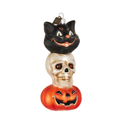 glass Halloween ornament with black cat on a skull with pumpkin base