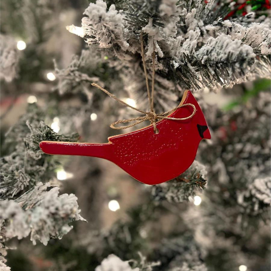 red cardinal ornament hanging on a Christmas tree.
