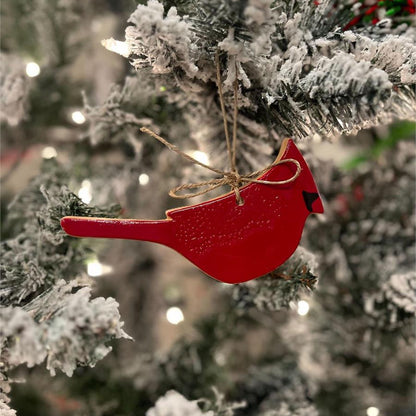 red cardinal ornament hanging on a Christmas tree.