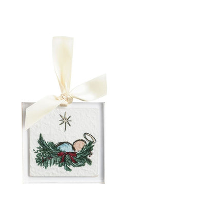 acrylic ornament with image of baby jesus laying in a manger of evergreens with a red bow on it and a star above him