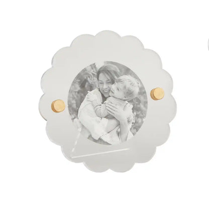 round acrylic photo frame with black and white image of a person holding a child in it