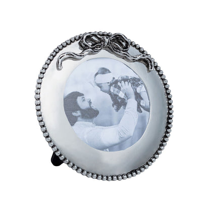 Round decorative photo frame with a bow design on a white background