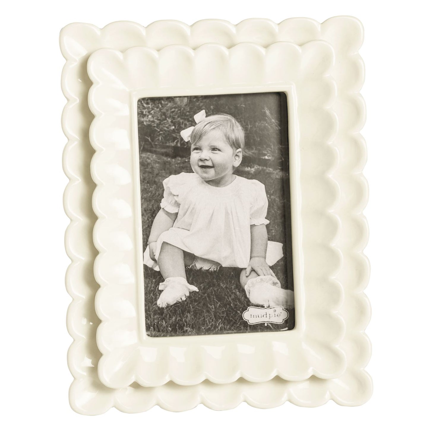 small White scalloped photo frame with a black and white photo of a child inside