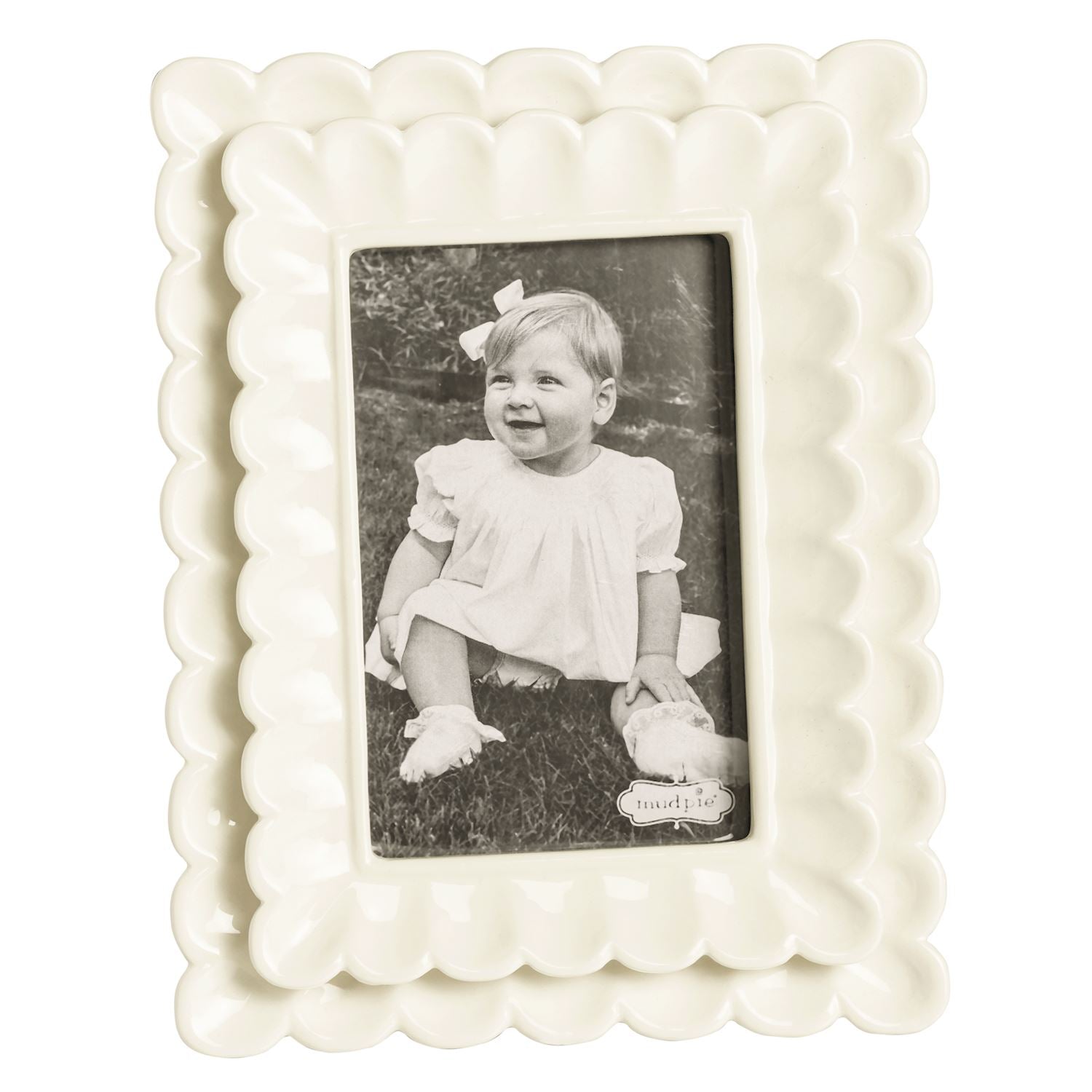 small White scalloped photo frame with a black and white photo of a child inside