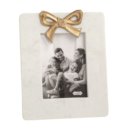 large white marble frame with gold bow and black and white picture in it