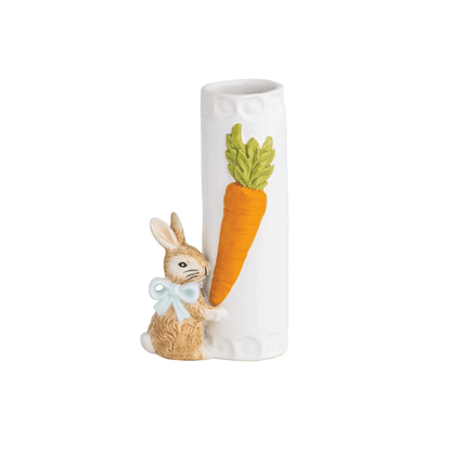 white vase with carrot design on it and a little brown bunny attached to the bottom wearing blue bow around its neck