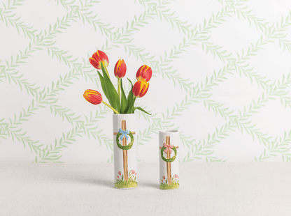 2 sizes of white vases with cross designs, larger vase has tulips in it