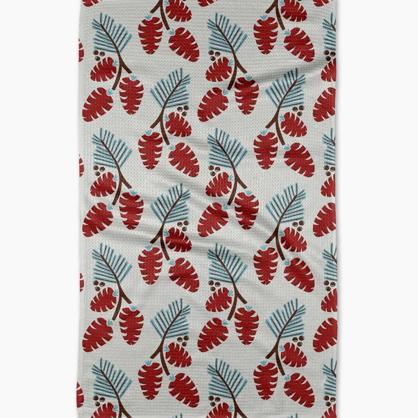 white towel with pine branch and pine cone design laying on a white surface