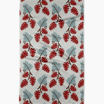 white towel with pine branch and pine cone design laying on a white surface