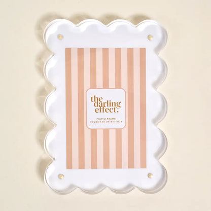 Decorative photo frame with scalloped edge and beige striped insert card on a beige background