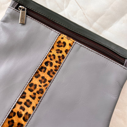 close-up of grey greta bag with animal print stripe down the center and zipper at the top.