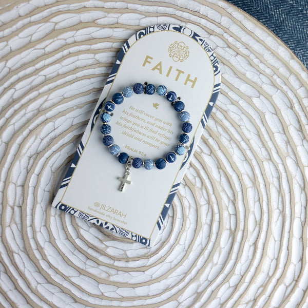 blue faith bracelet with silver cross on card packaging.
