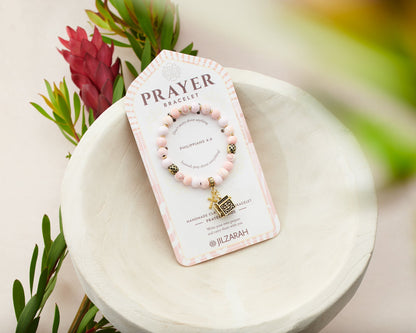 rose beaded bracelet with gold cross and prayer box charms on card packaging.