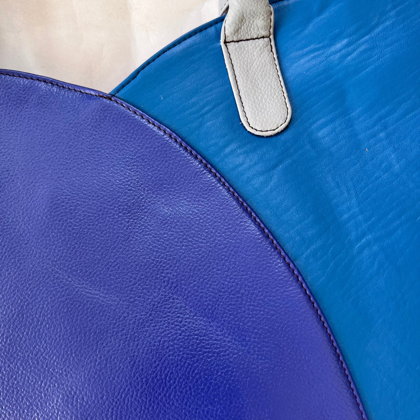close-up of other side of valeria tote that is half bright blue and half royal blue.