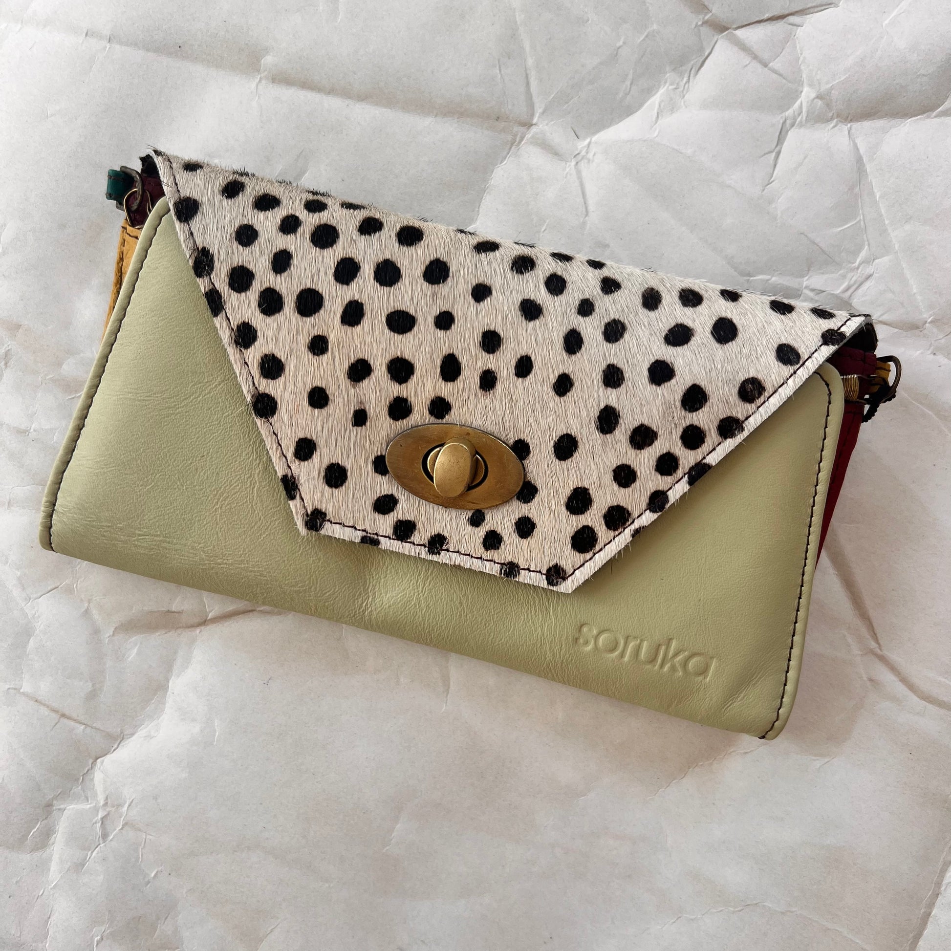 mint secret clutch wallet with black and white animal print flap.