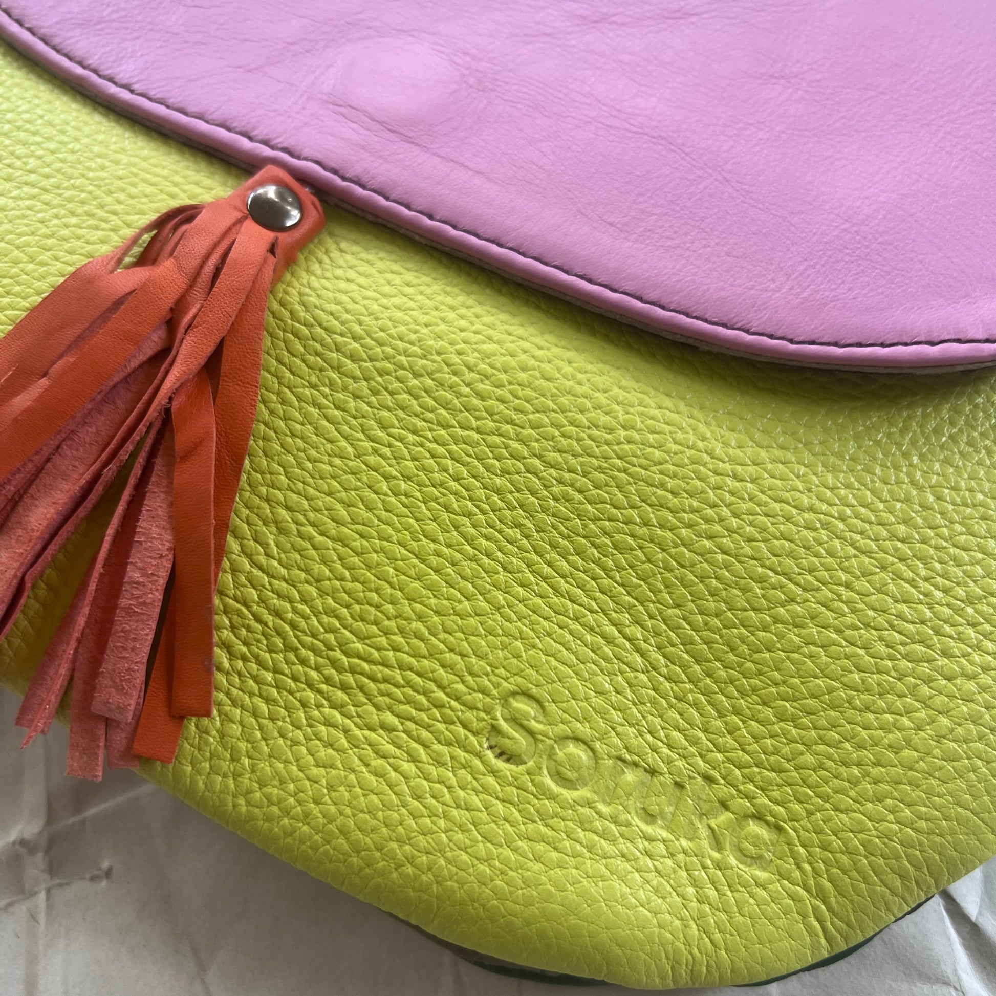 close-up of other yellow side of orange tassel Lola Reversible Crossbody