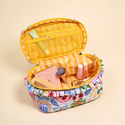 Open makeup case with colorful items on a beige background