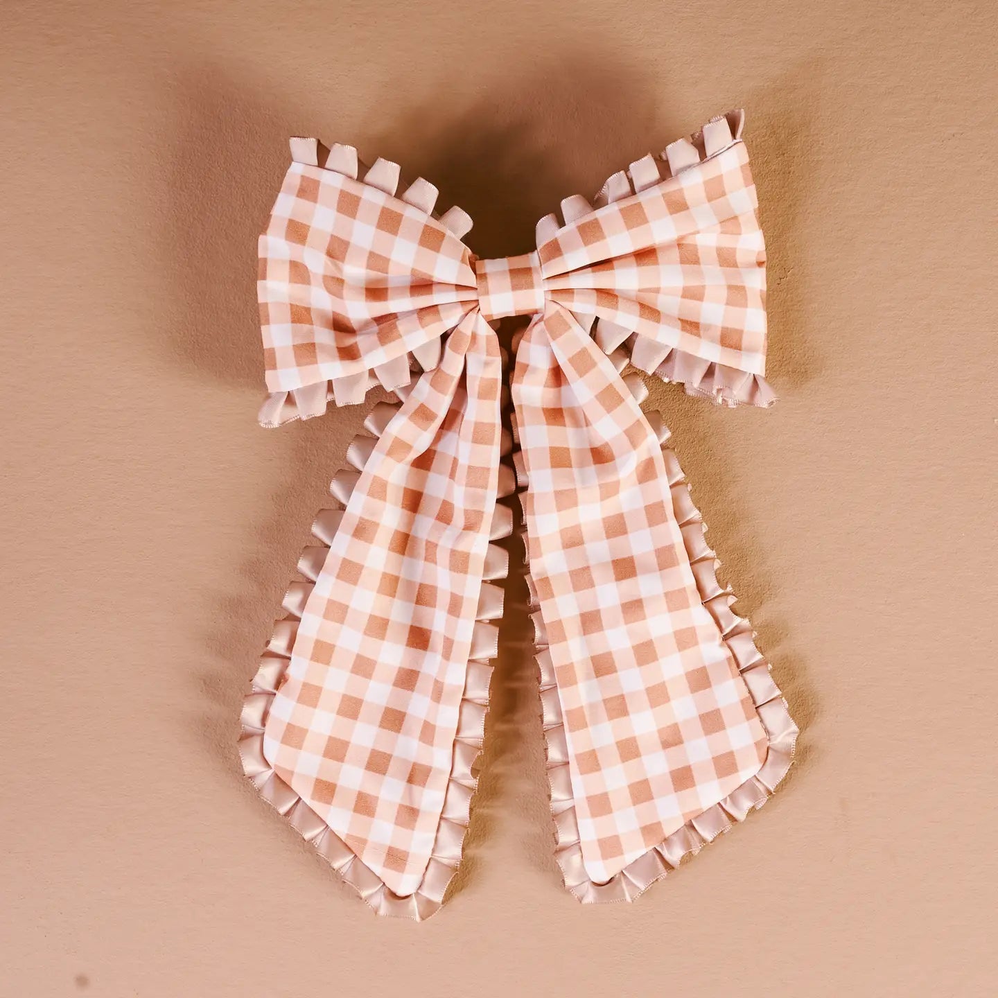 maple gingham Fancy Frills Hair Bow shown on a beige background