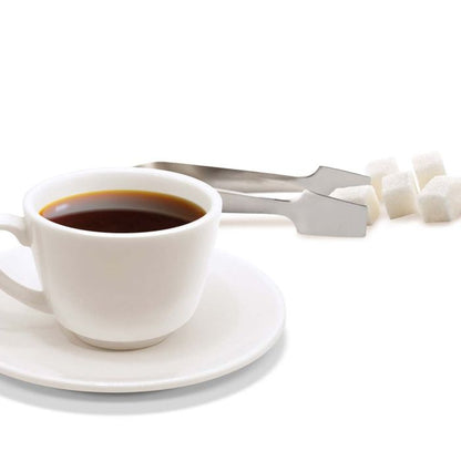 cup of coffee with sugar cubes and tongs set near it