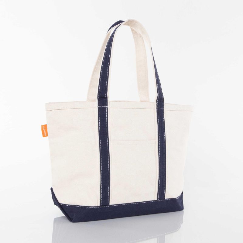 angled view of off white tote with navy blue trim and handles