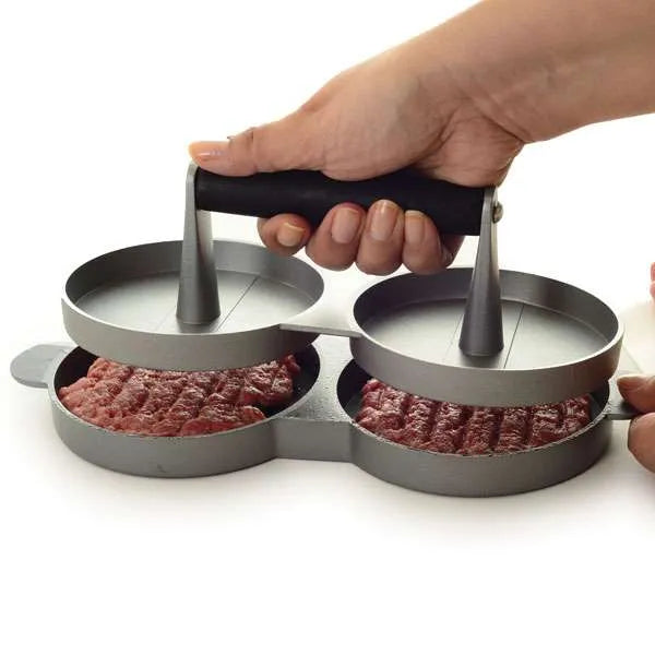 Hand holding lid of burger press to press two burgers