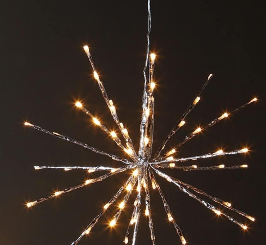 silver starburst with twinkle lights turned on shown on a black background .