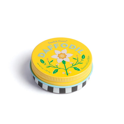 tin of daffodil lip balm with yellow lid and black and white striped base
