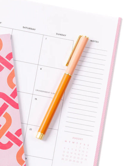 coral so darling pen laying on a calendar.