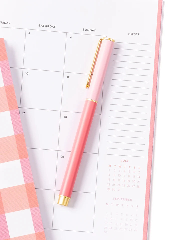 pink so darling pen laying on a calendar.