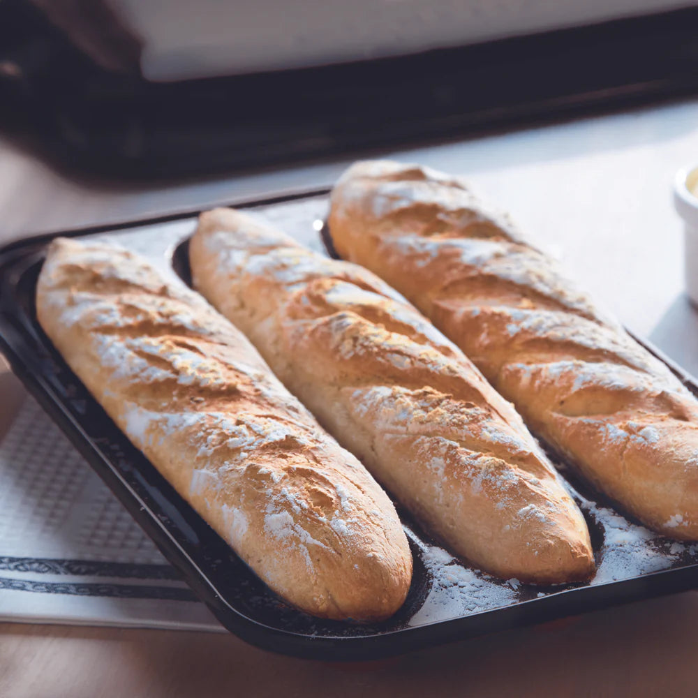 base of Baguette Baker with 3 baked loafs in it