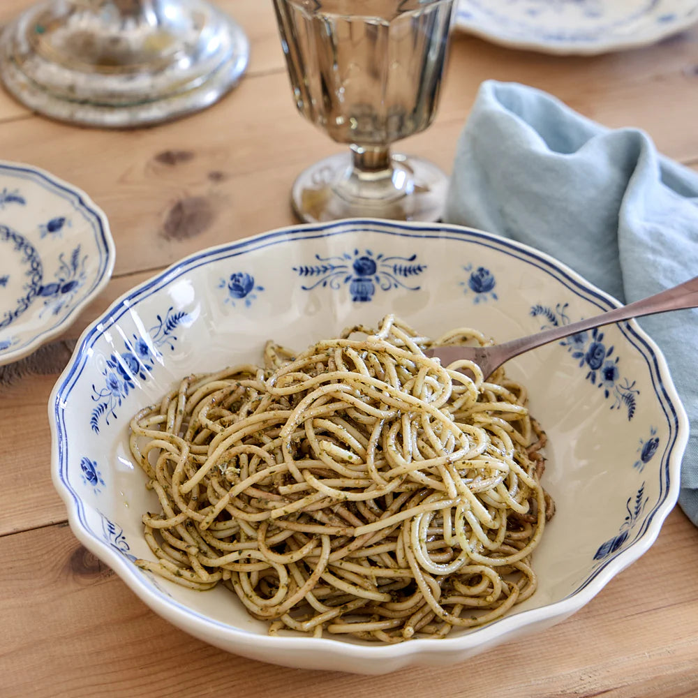 costa nova vila beige and blue pasta bowl on a set table with pasta in the bowl