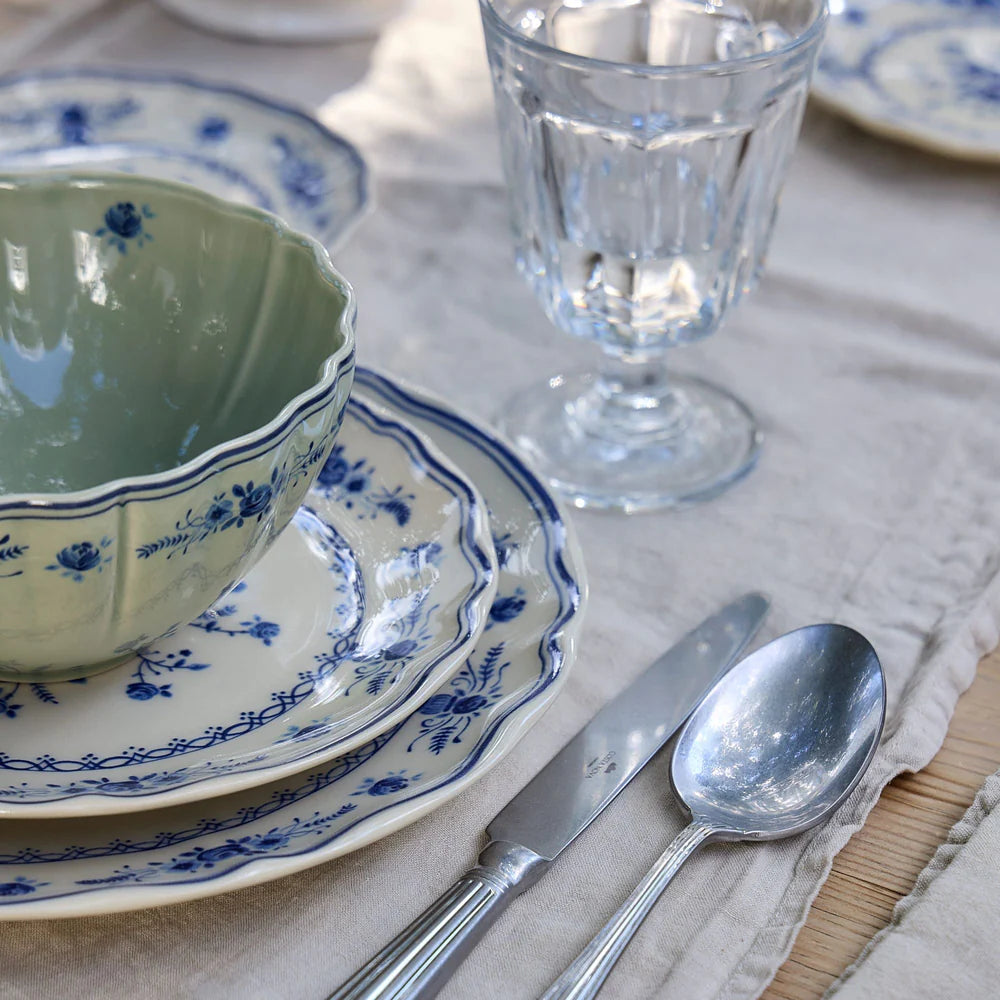 close-up of costa nova vila olive green and blue place setting pieces on a set table