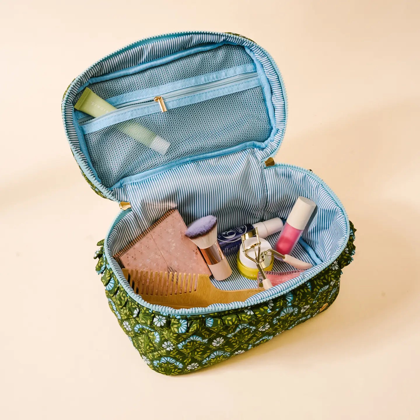 interior view of Everbloom Forest Green Glam & Go Quilted Cosmetic Bag filled with cosmetics