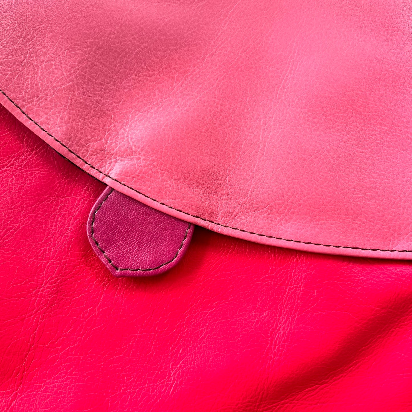 close-up of shades of brown striped greta bag with zipper across the top.