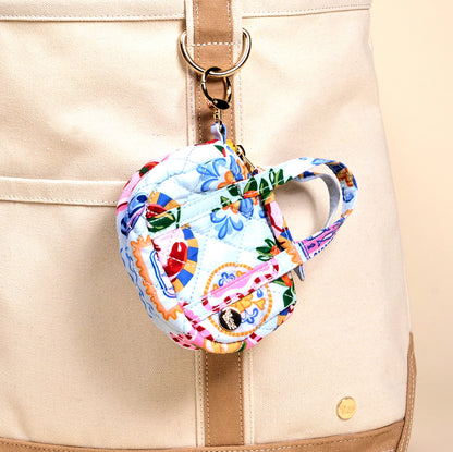 tiny bag charm bag clipped on the handle on a tote bag