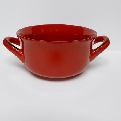 red handled soup bowl on a white background.