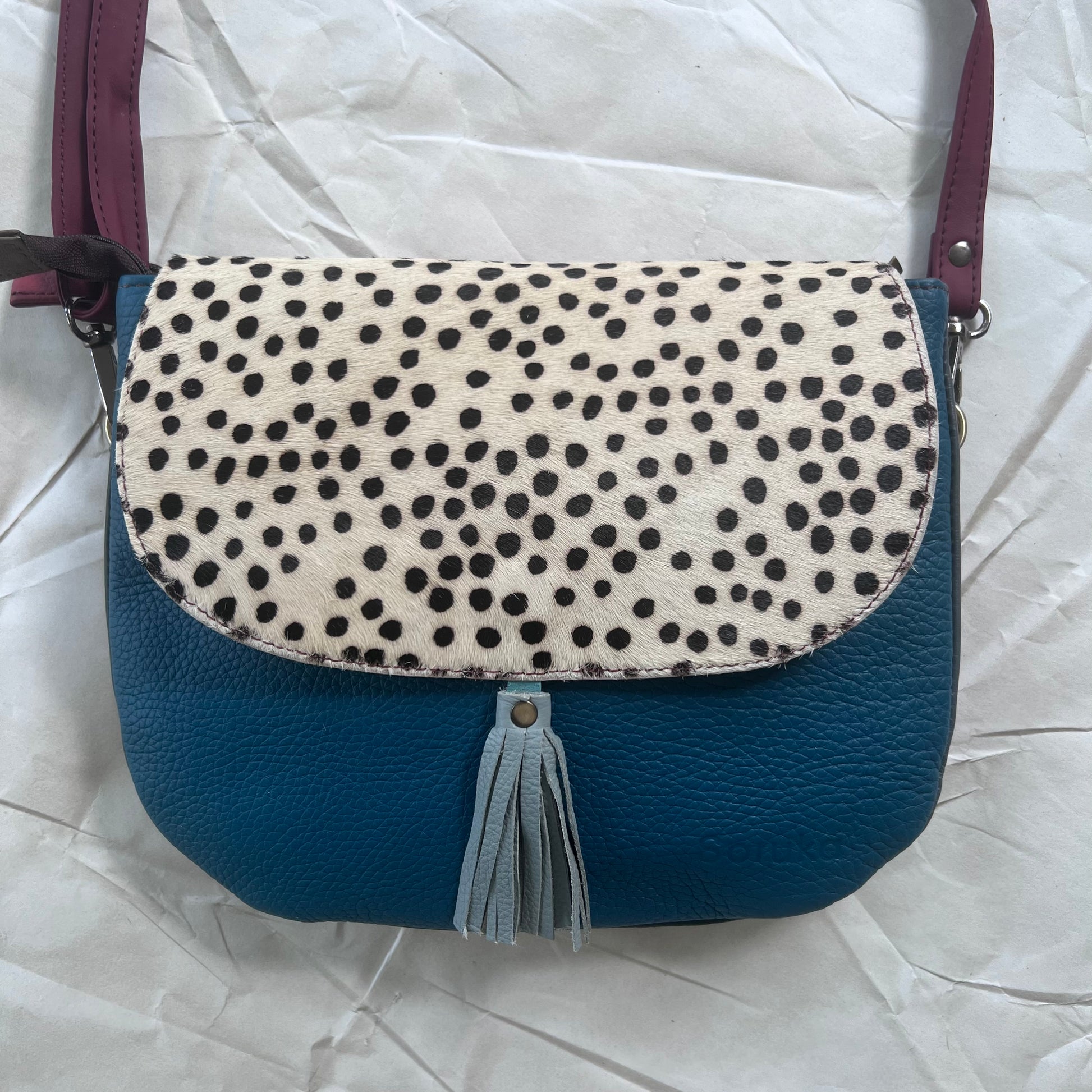 Lola Reversible Crossbody with blue body, white with black dots animal print flap and blue tassel
