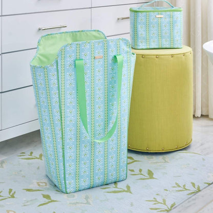 Blue and green patterned laundry basket set next to a yellow stool on a light-colored floor.
