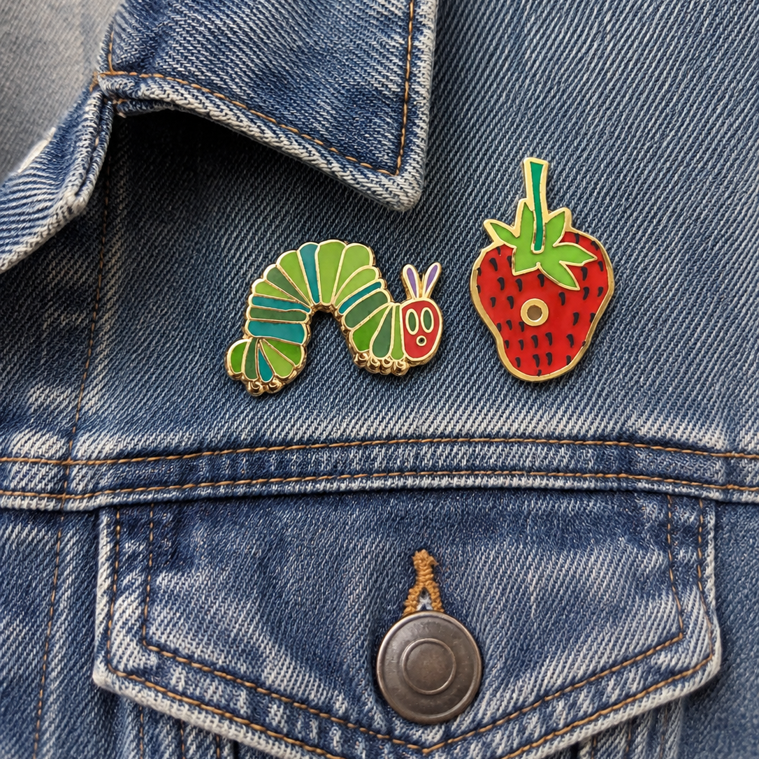 2 enameled pins on a denim jacket