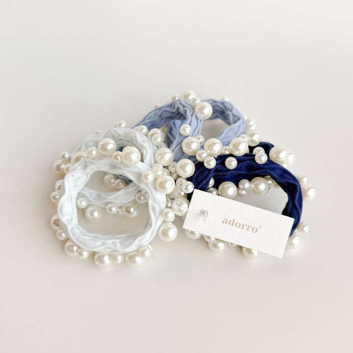 6 assorted hair ties with pearls on them in a pile
