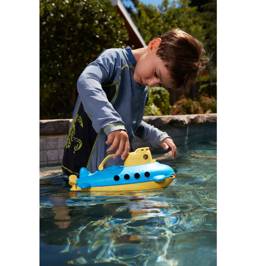 child playing with submarine in a swimming pool.