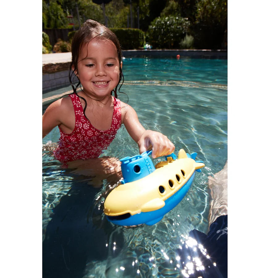 another child holding the submarine while playing a  pool.