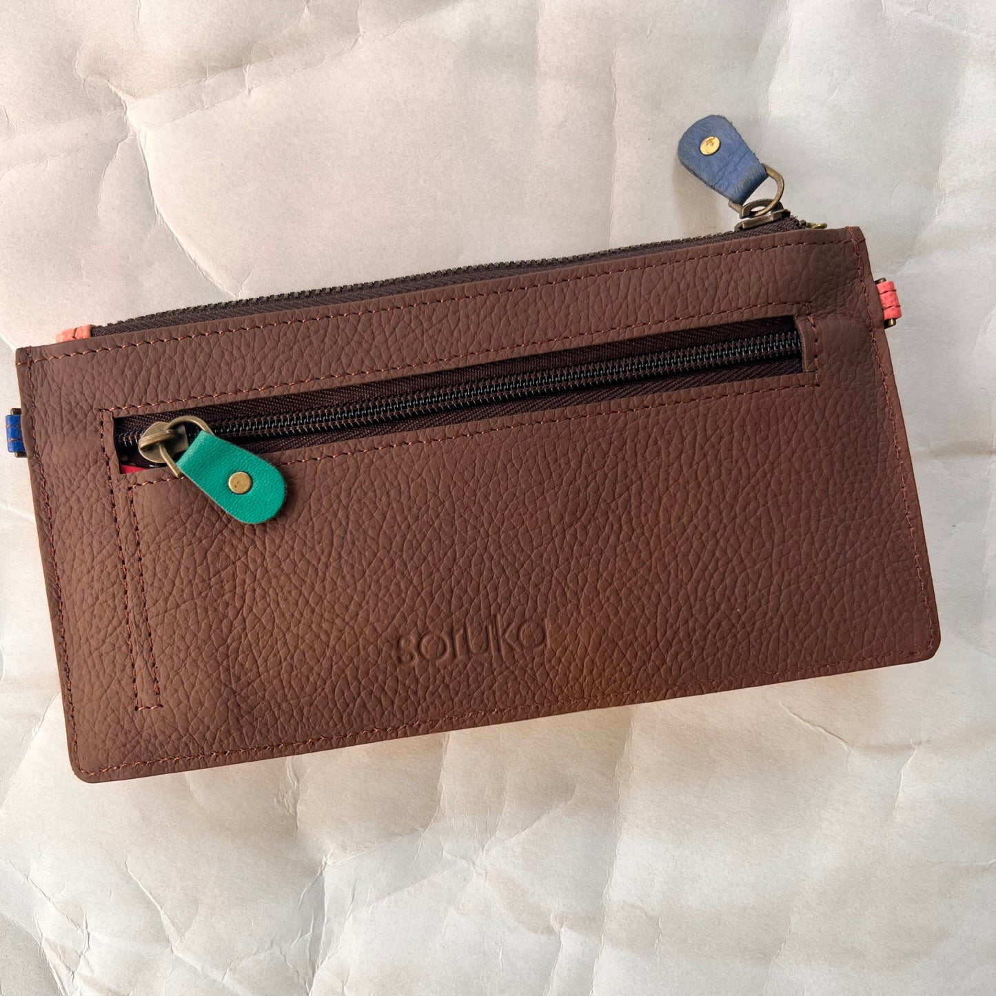 solid brown back of kimber wallet with zipper pocket.