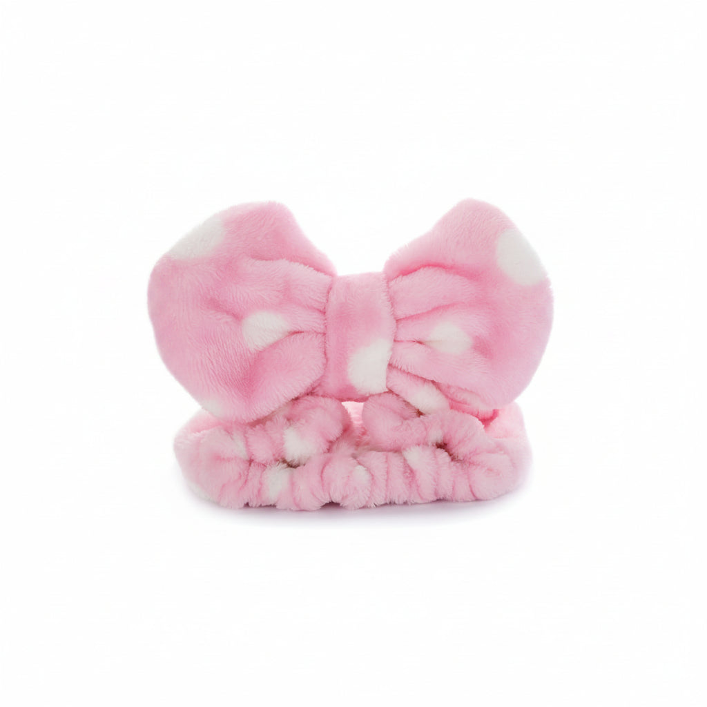Pink fluffy bow-shaped headband on a white background