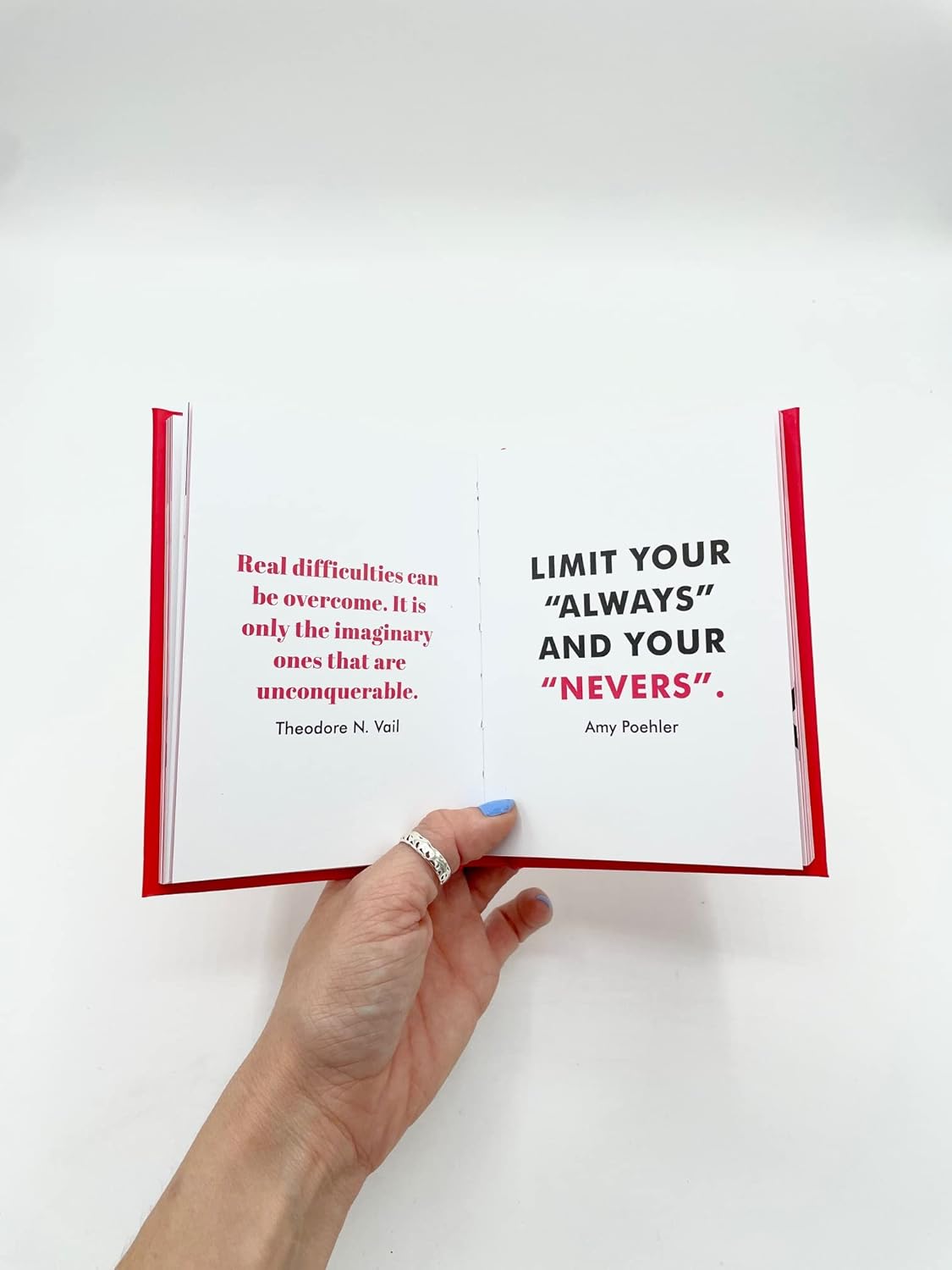 Hand holding an open book with more motivational quotes 