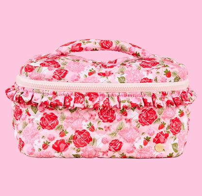 Floral-patterned cosmetic case on a pink background