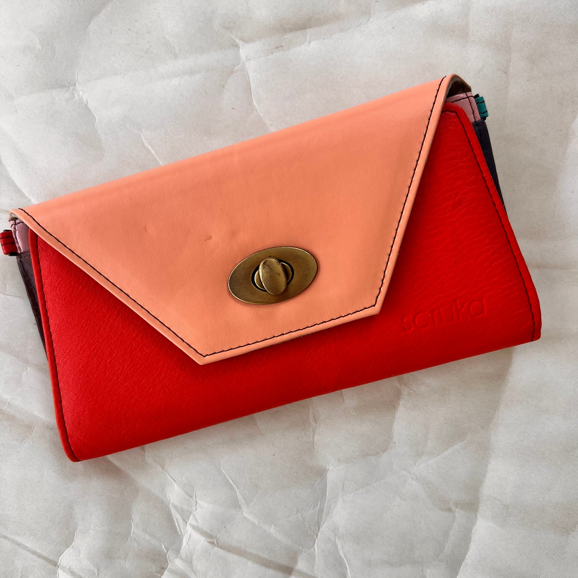 red secret clutch wallet with pink flap.